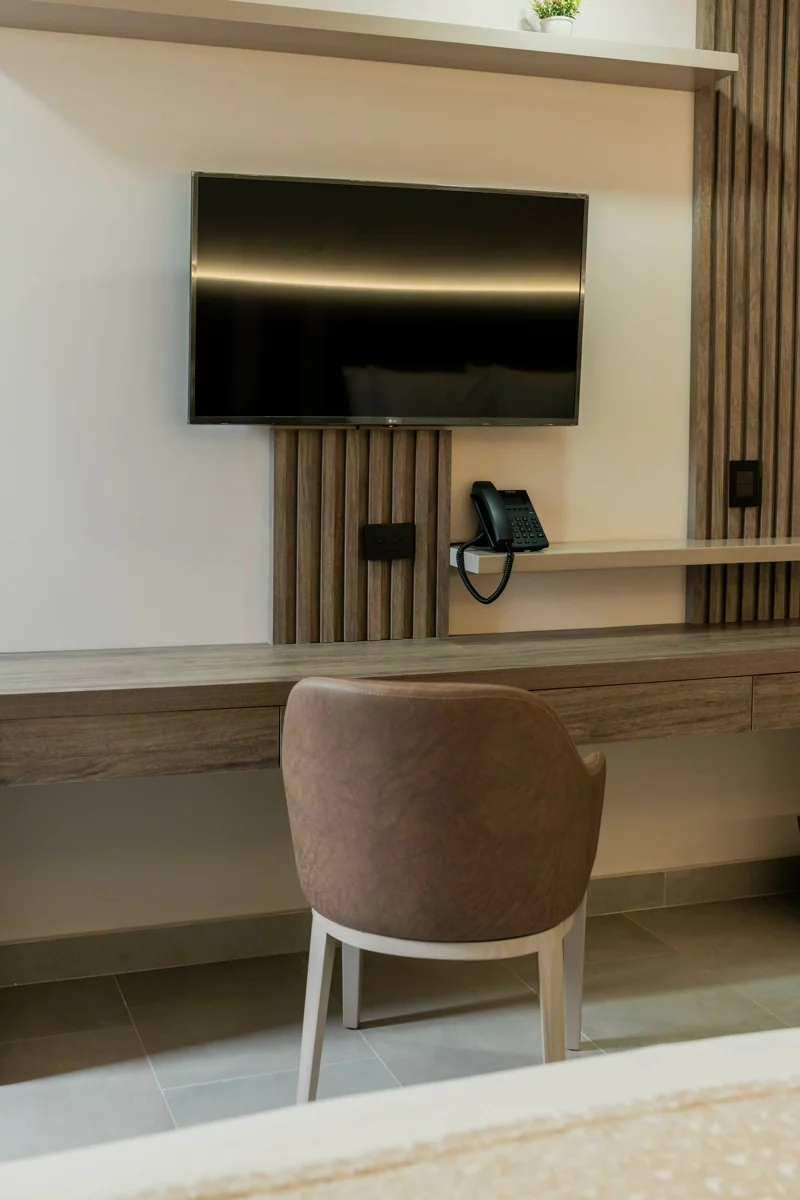 Escritorio con silla tapizada y televisor de pared